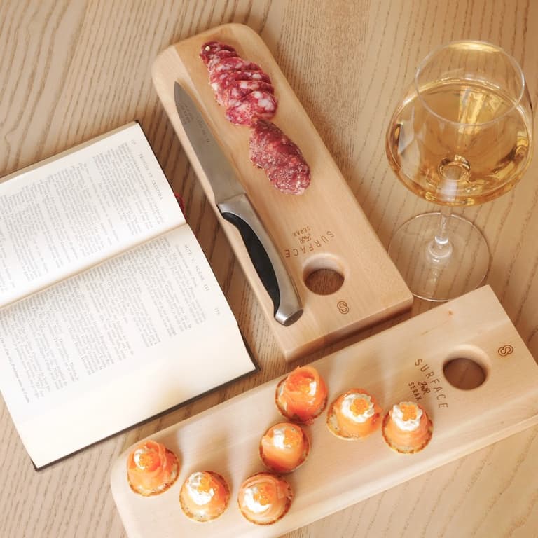 Apéritif avec vin blanc, livre, coupelles et planches en bois Serax