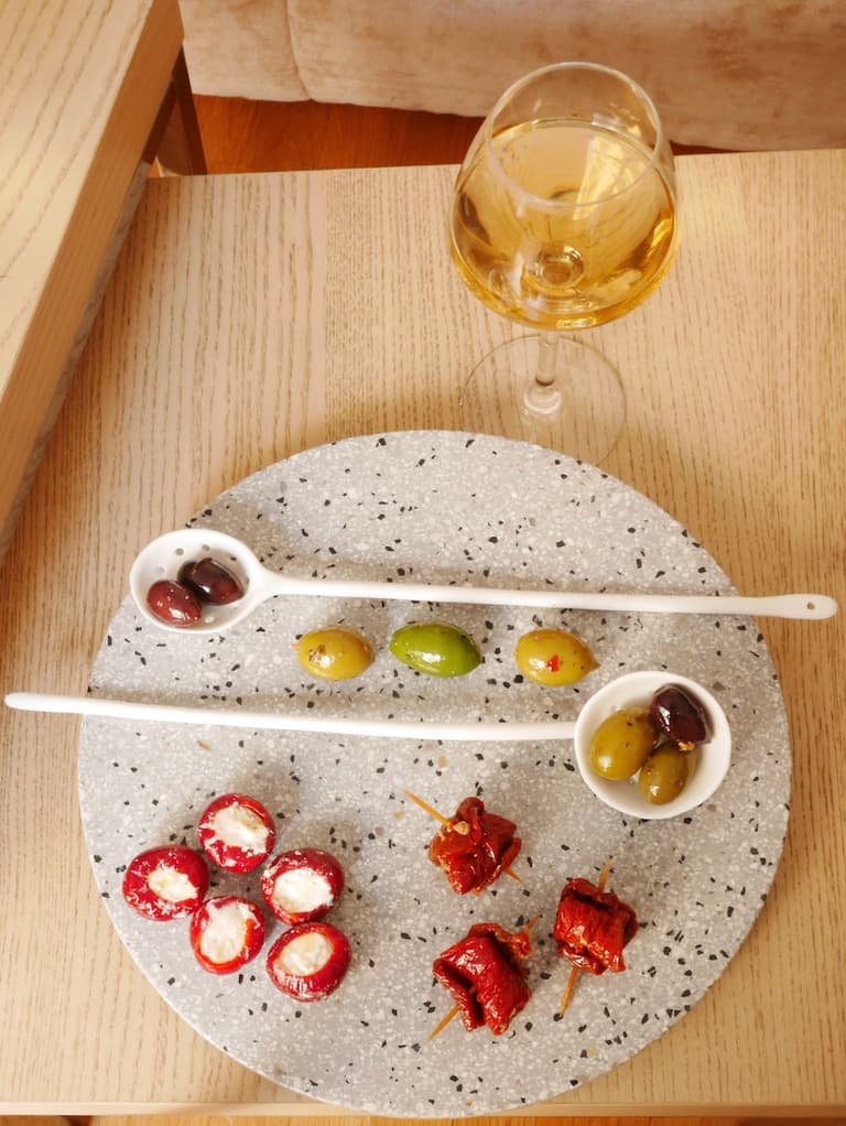 Olives et amuse-bouches italiens présentés dans des coupelles sur une table basse