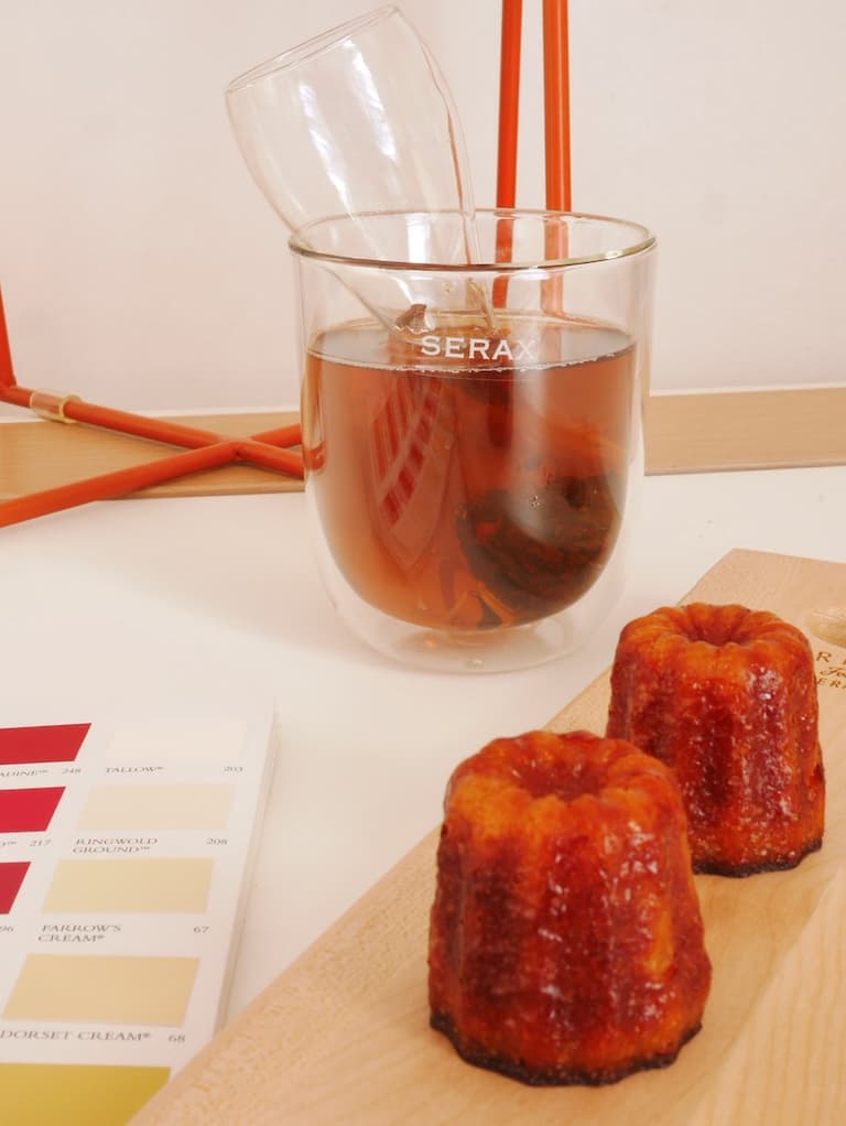 Mug Serax avec infuseur en verre et cannelé posé près d’un ordinateur