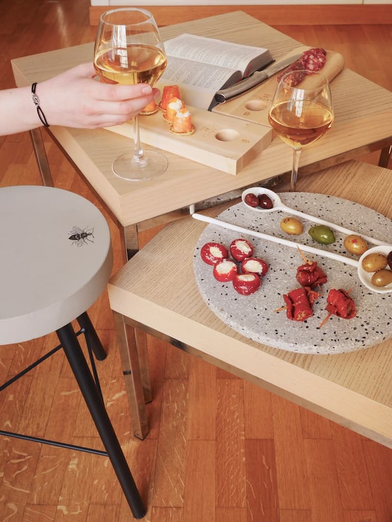 Apéritif entre amies avec tabouret en béton, verre de vin et vaisselle Serax