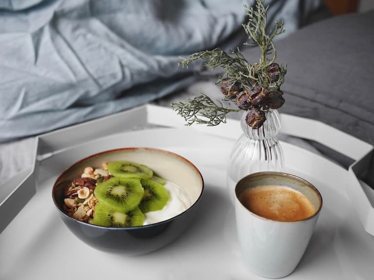 Bol de granola et tasse bleue Serax posés sur un plateau de petit déjeuner
