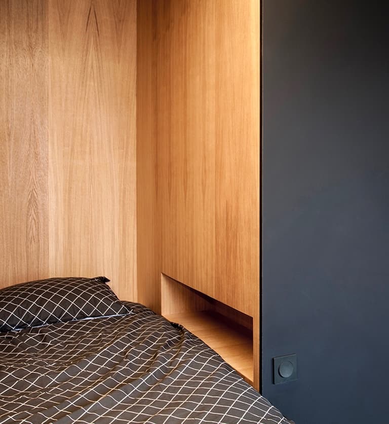 Intérieur chambre cube noir paroi bois table de chevet incrustée prise interrupteur clematc