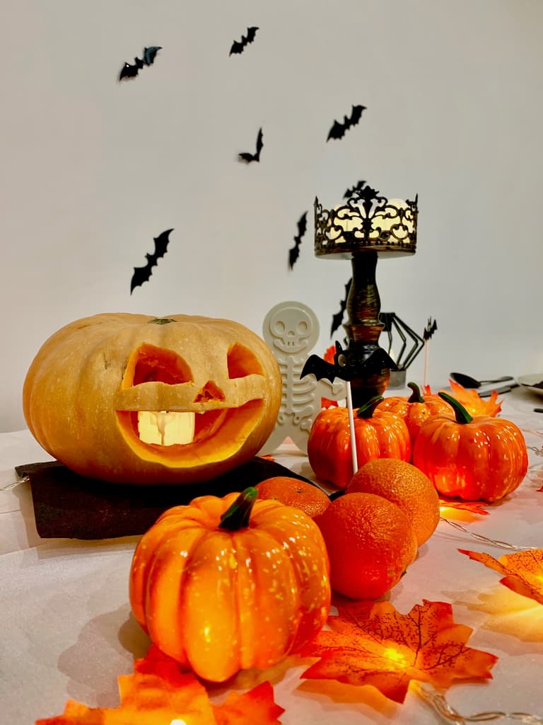 petites citrouilles, chandelier noir et emporte-pièce squelette parmi les gourmandises d'Halloween