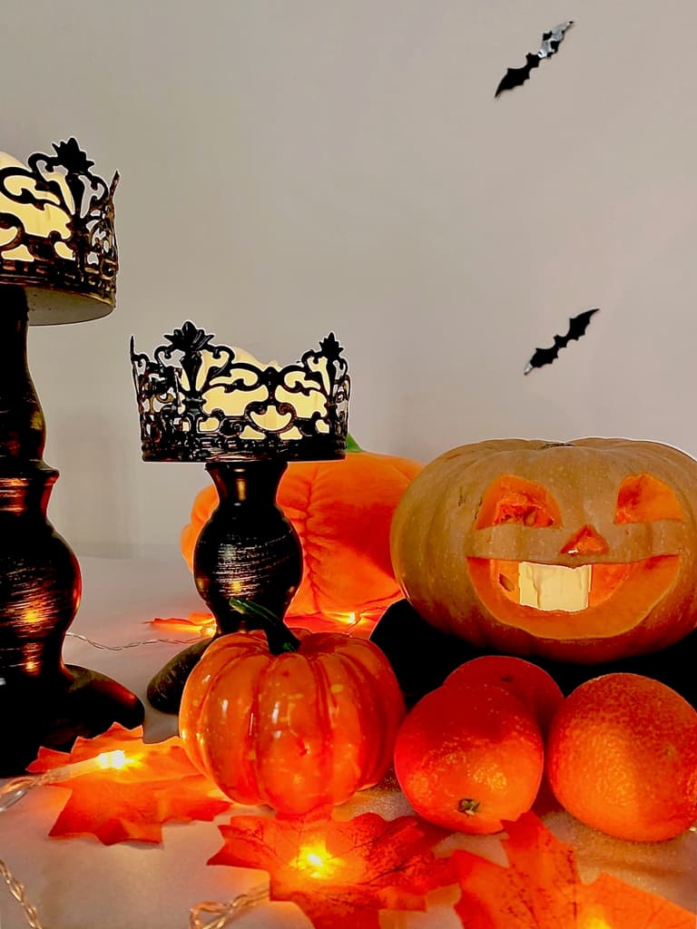chandelier noir, clémentines, feuillages d'automne et chauves-souris murales pour Halloween