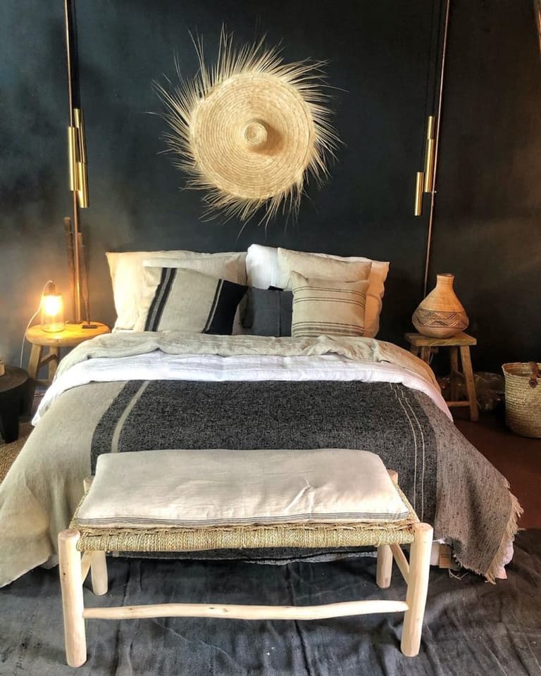 chambre bohème avec lit gris, chapeau de paille et décoration murale