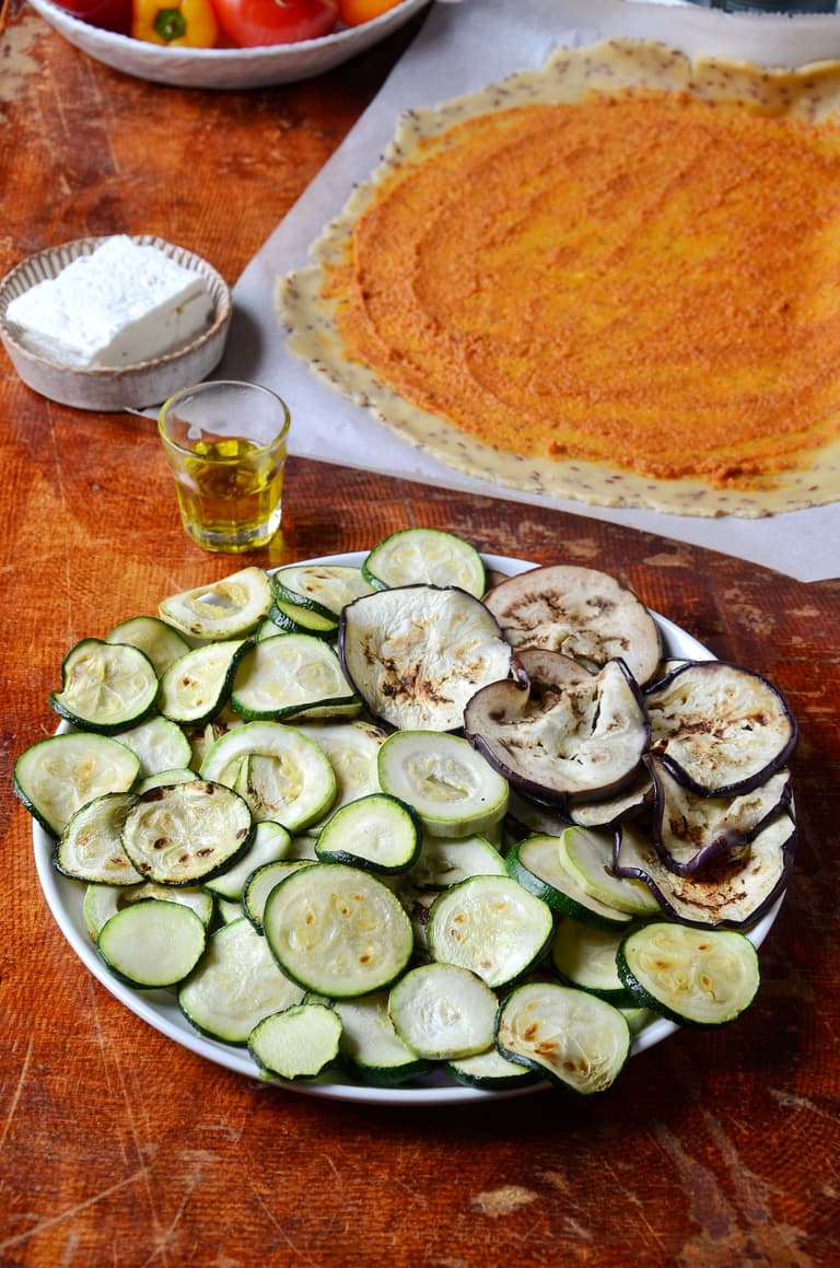 Pesto rosso étalé sur le fond de tarte rustique