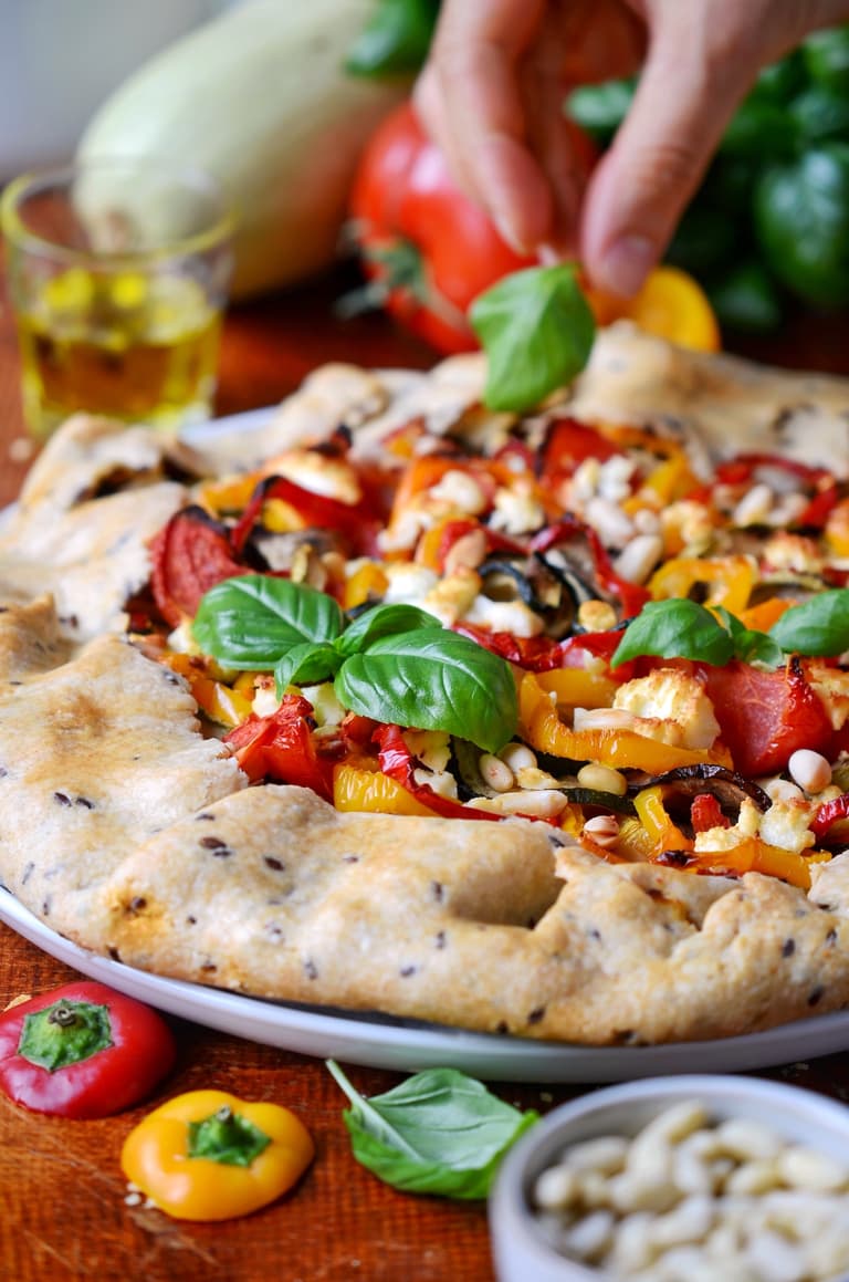 Part de tarte aux légumes du soleil, feta, pignons et basilic