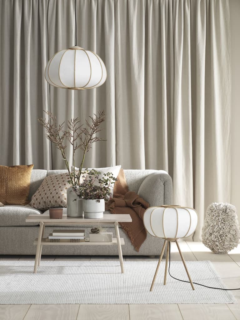 salon élégant canapé gris lampe laiton coussin orange table basse bois