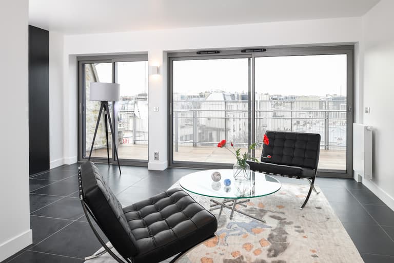 salon moderne blanc noir carrelage fauteuil Barcelona chauffeuse cuir