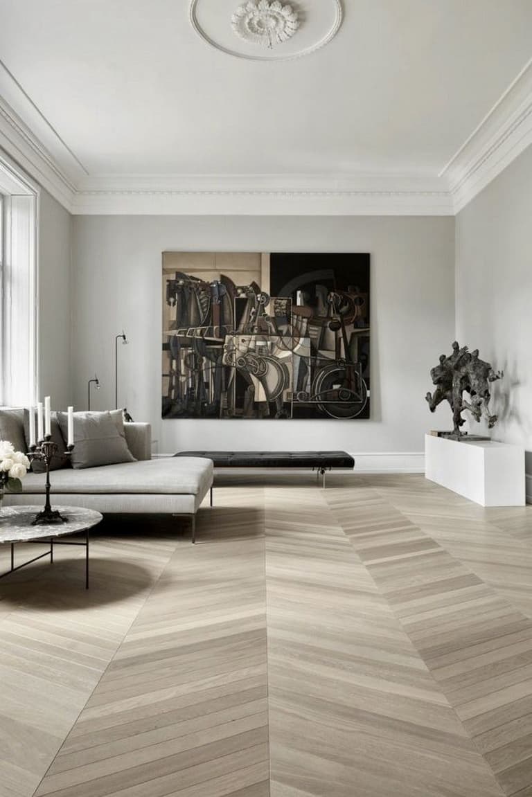 salon spacieux sophistiqué parquet chevron moulures murs table basse ronde marbre