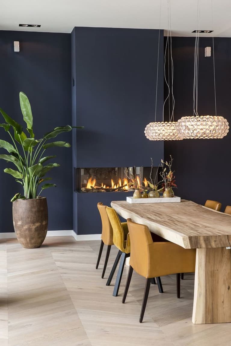 salle à manger table bois brut chaises jaunes moutarde mur bleu marine parquet bois lamé