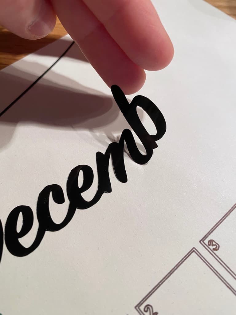 Pose du mot Décembre en lettres noires au-dessus de la grille du calendrier