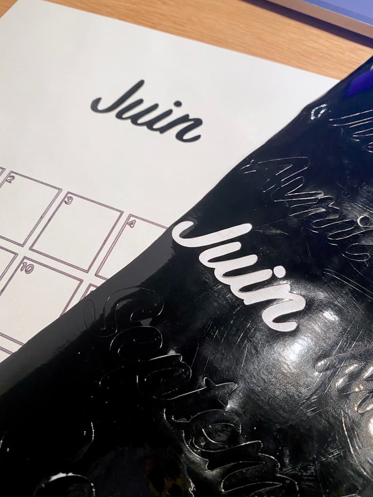 Découpe du mot Juin dans un adhésif noir brillant avec une machine Cricut