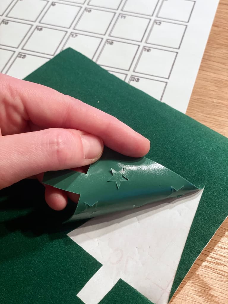 Retrait du papier protecteur d’un motif découpé dans un adhésif vert