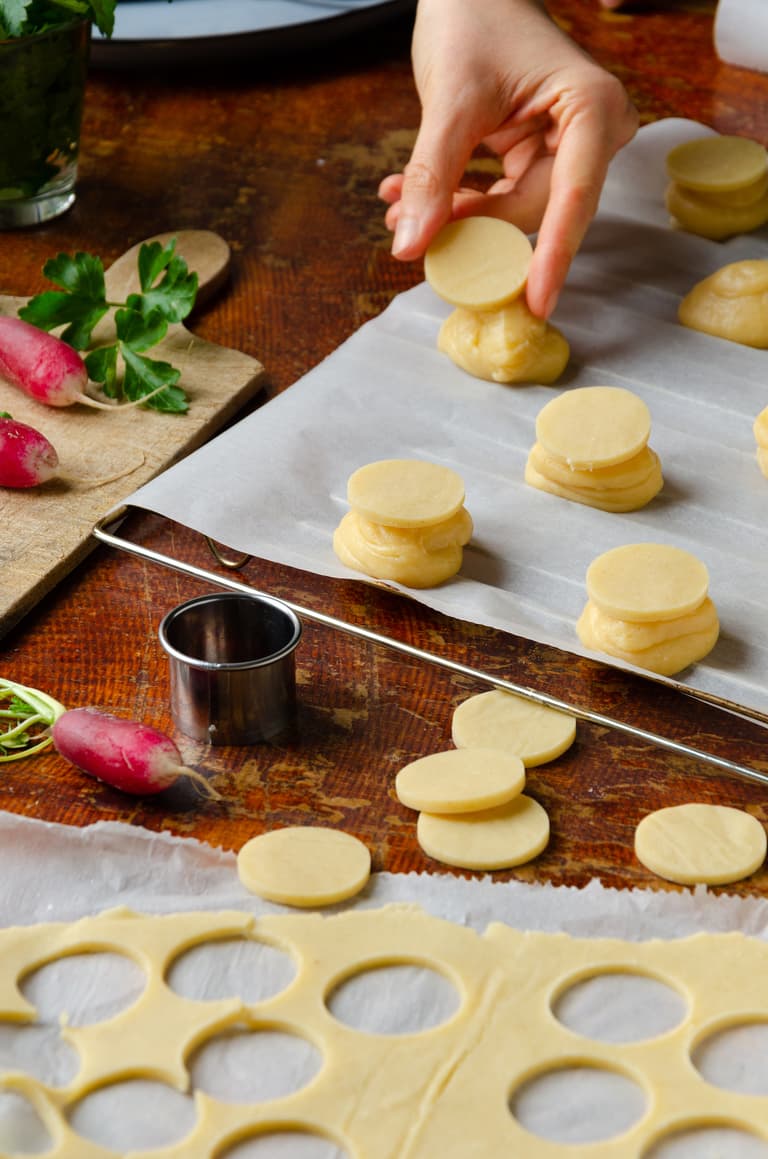 Choux pochés sur une plaque et recouverts de disques de craquelin