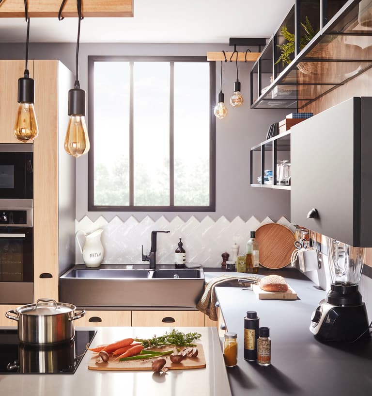 Cuisine noire et bois avec évier timbre d’office blanc et carrelage en chevrons