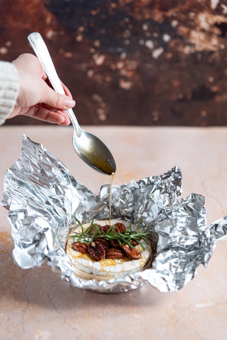 Boîte de camembert posée dans du papier d'aluminium avant cuisson