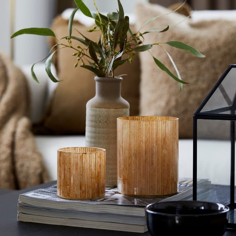 trois vases ocre au centre d’une table basse