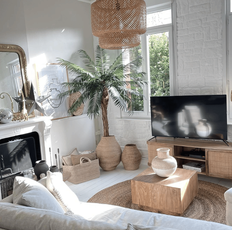 Salon blanc avec suspension, meuble en cannage et accessoires naturels