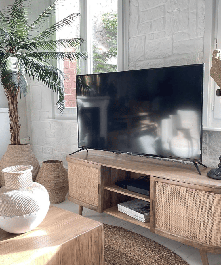 Salon blanc avec suspension, meuble en cannage et accessoires naturels
