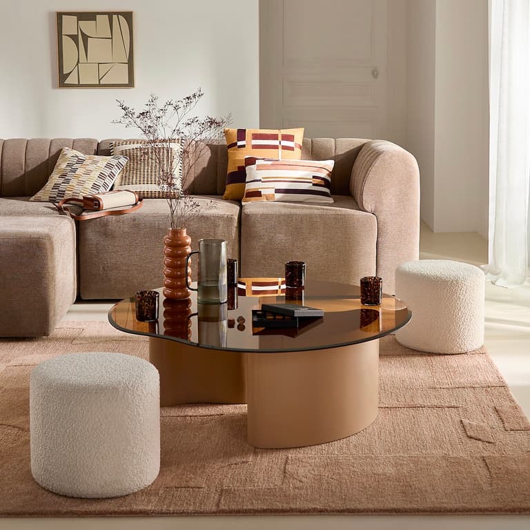Salon beige et marron avec table en verre et assises arrondies