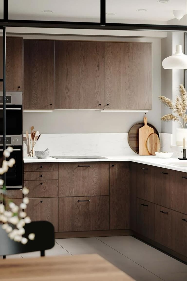 Cuisine en L avec façades en bois foncé, plan de travail blanc et verrière noire