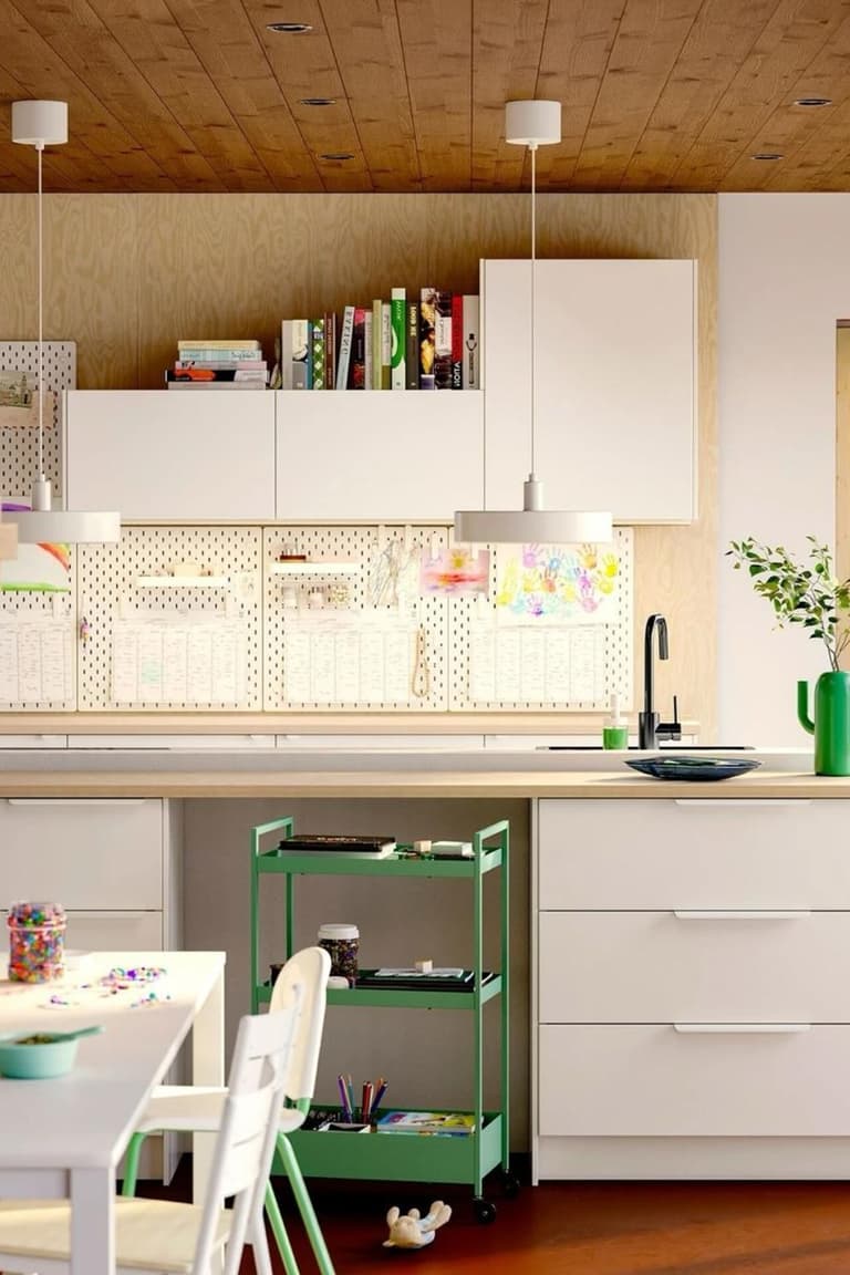 Cuisine familiale claire avec plan de travail effet bois, crédence graphique et desserte verte