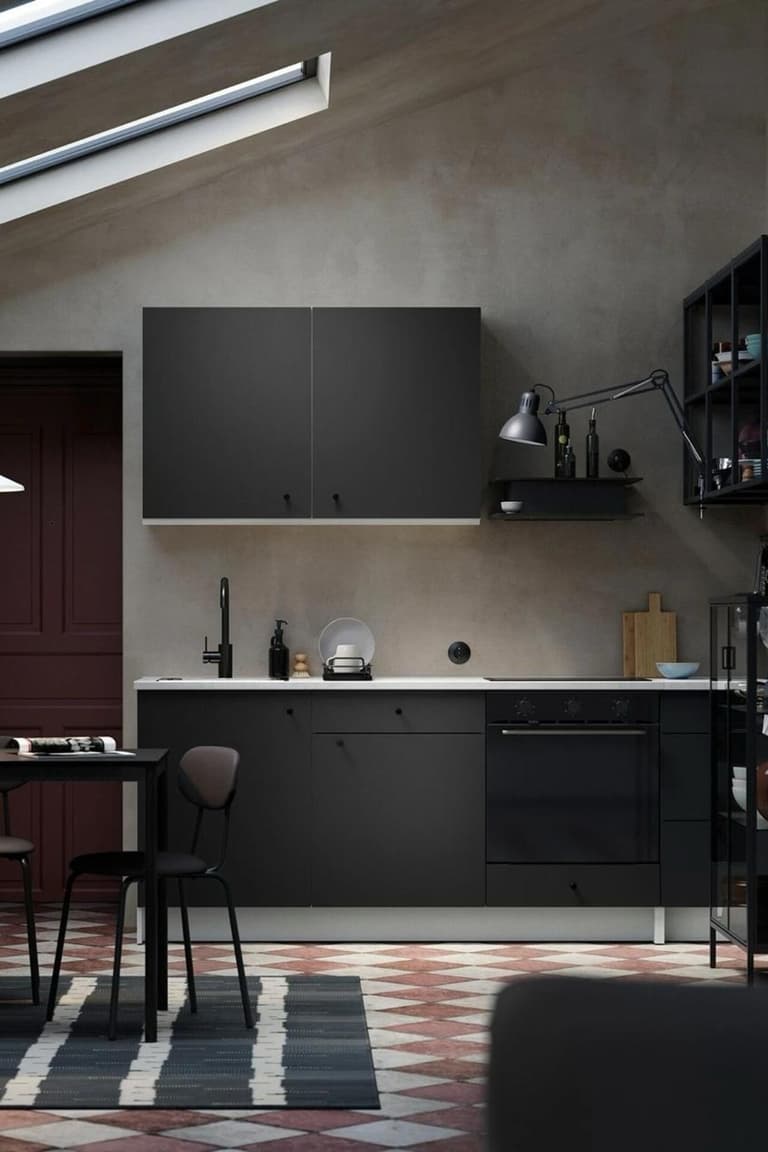 Cuisine contemporaine sombre avec long plan de travail noir, rangements muraux et ambiance atelier