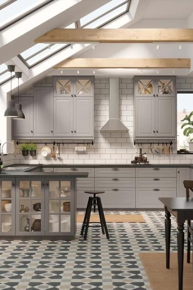 Cuisine sous verrière avec îlot central, plan de travail sombre et sol graphique