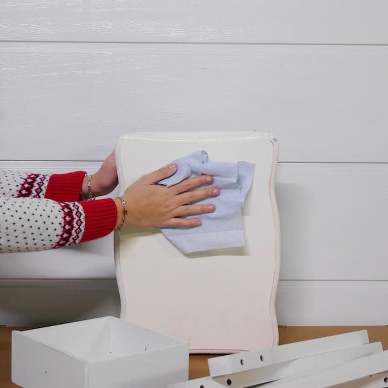 Dépoussiérage d’un panneau blanc de table de chevet avec un chiffon microfibre