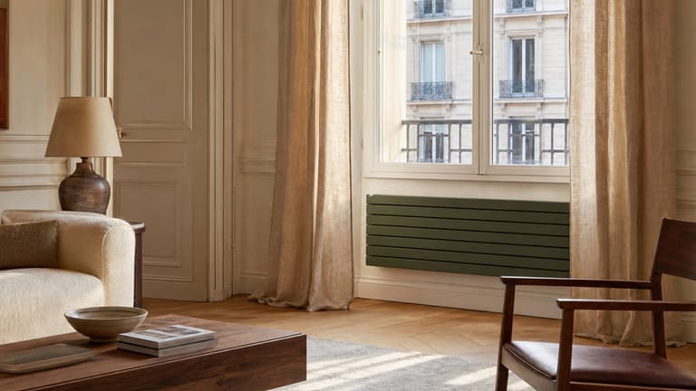Radiateur horizontal vert olive sous une fenêtre dans un salon parisien