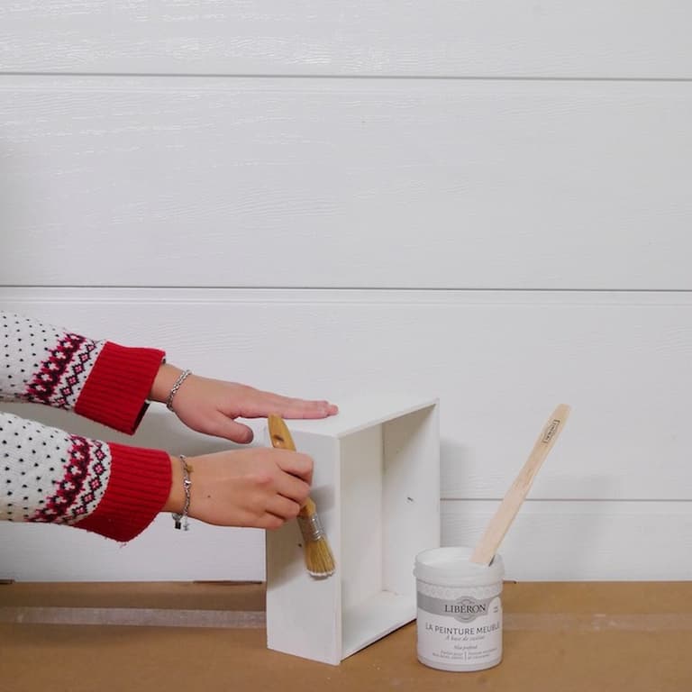 Mise en peinture de l’intérieur blanc de la table de chevet avec un petit pinceau