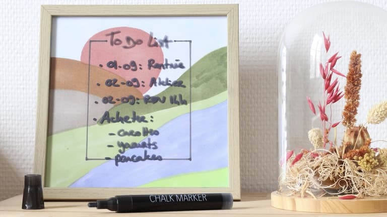 Tableau to do list coloré dans un cadre en bois avec marqueur craie et fleurs séchées sous cloche