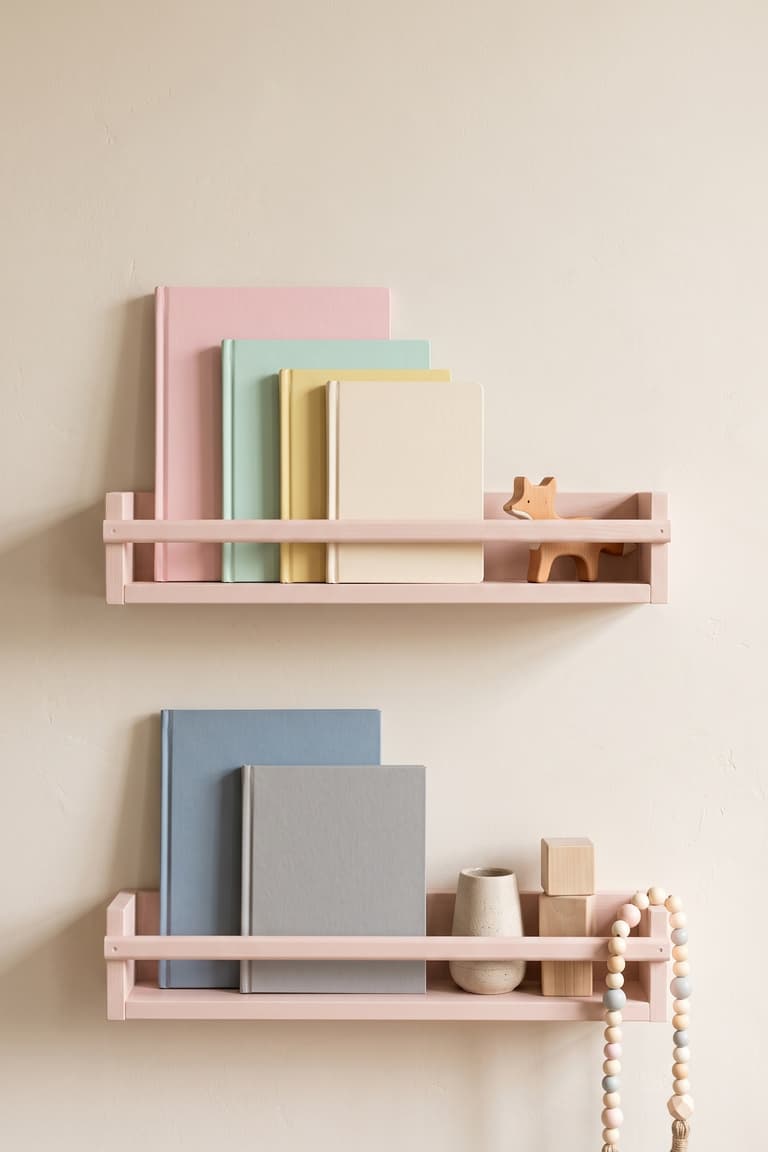 Deux étagères BEKVÄM rose poudré utilisées comme bibliothèque murale pour enfant