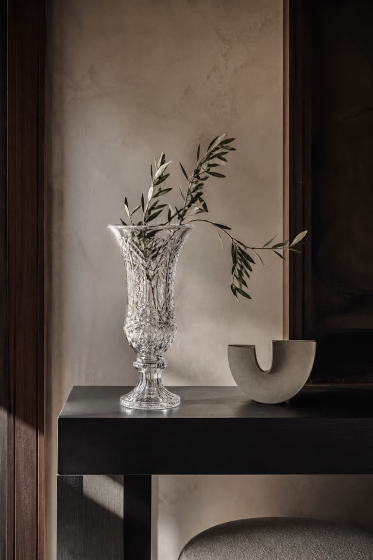 Vase en cristal ancien modernisé avec une branche sur une console contemporaine