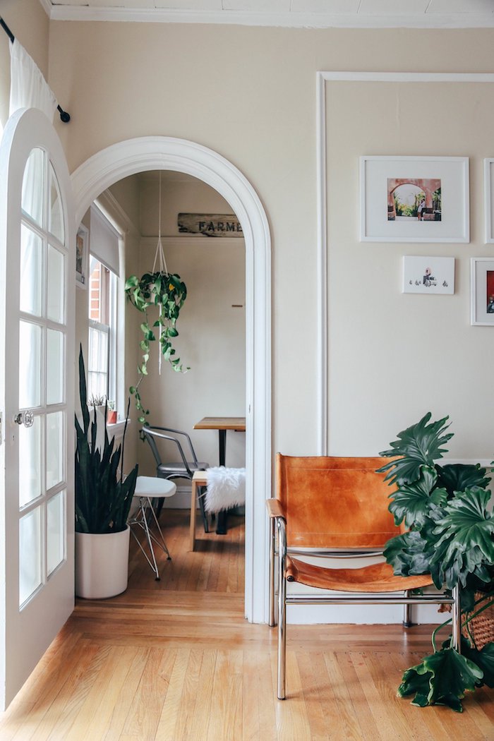 maison californienne fauteuil cuir plantes parquet mur blanc