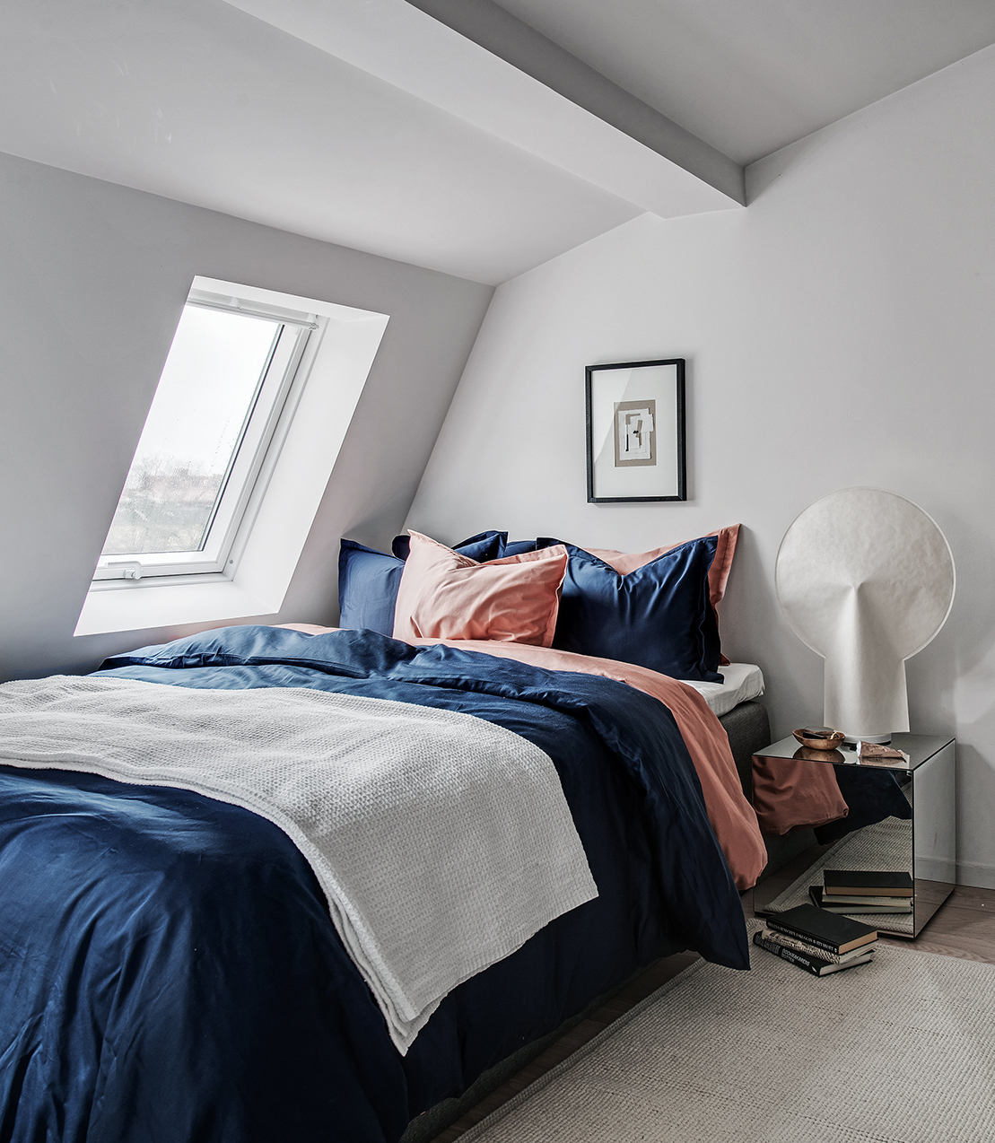 idée déco studio chambre lit bleu marine coussin rose saumon orange tapis beige toit blanc parquet blond - blog déco - clem around the corner