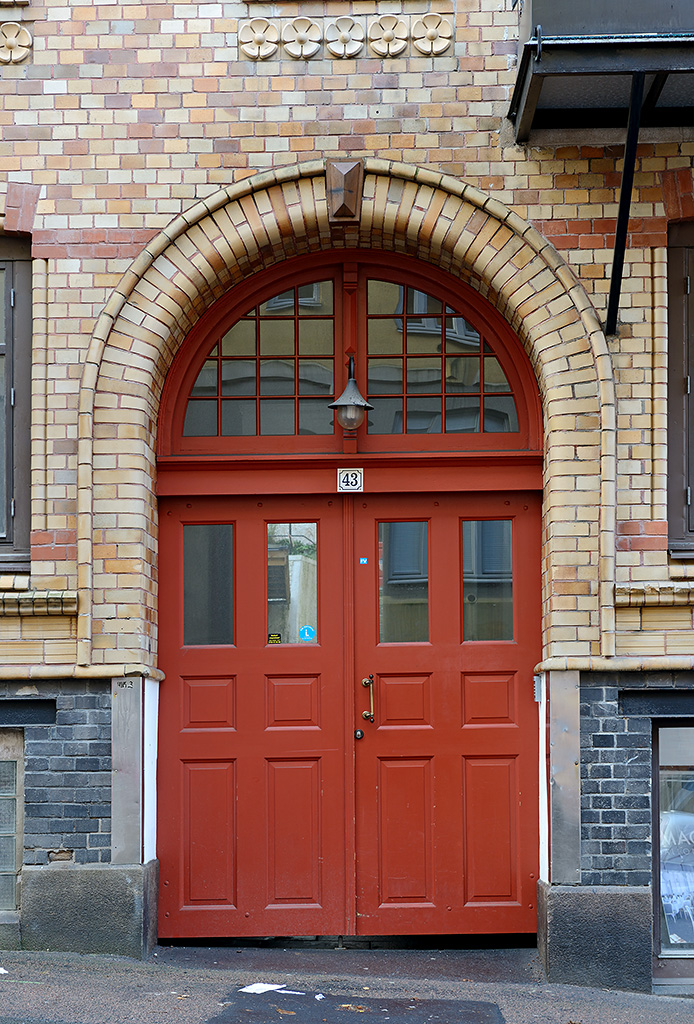 porte immeuble rouge mur brique orange marron gris rue suède - blog déco - clem around the corner
