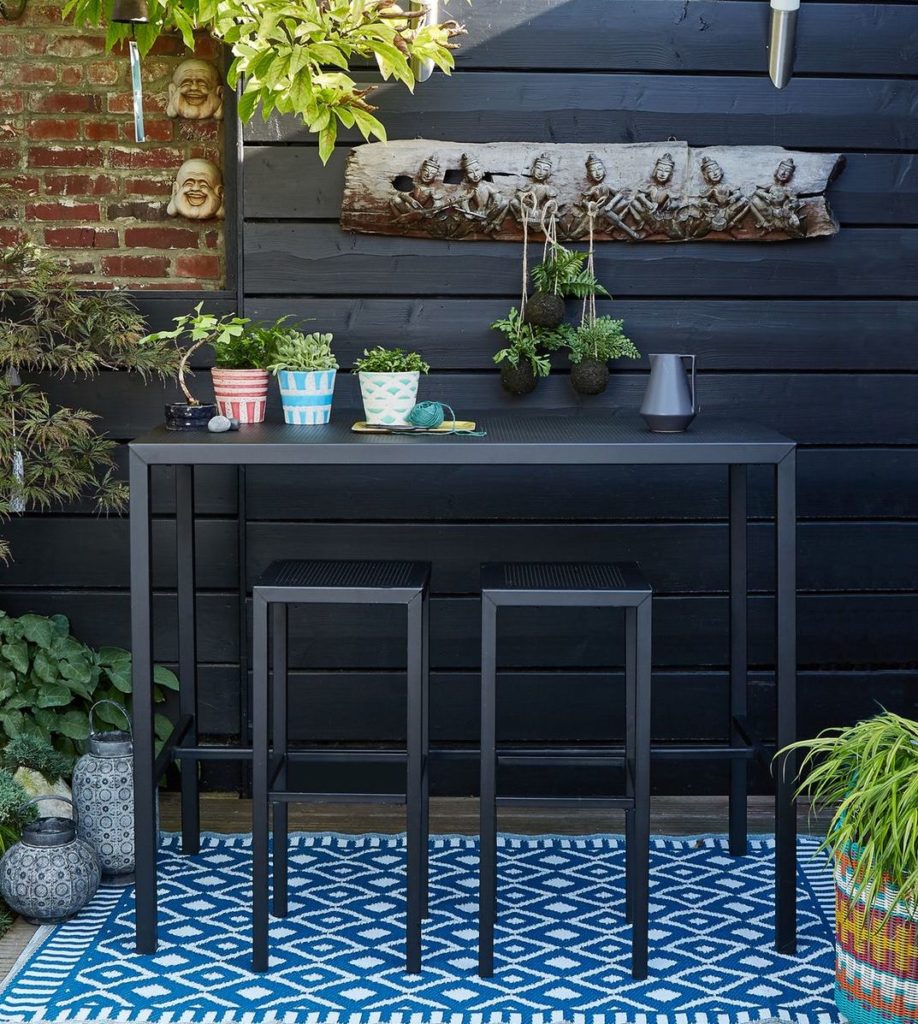 table haute métal noir perforé mur en bois et brique rouge clemaroundthecorner