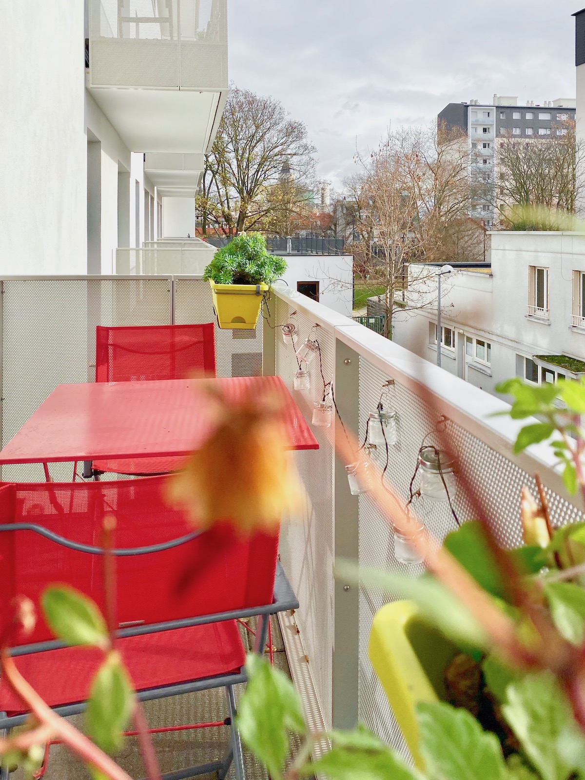 Basilique Saint-Denis balcon aménagement balcon table chaise rouge lafuma mobilier guirlande led bocal verre
