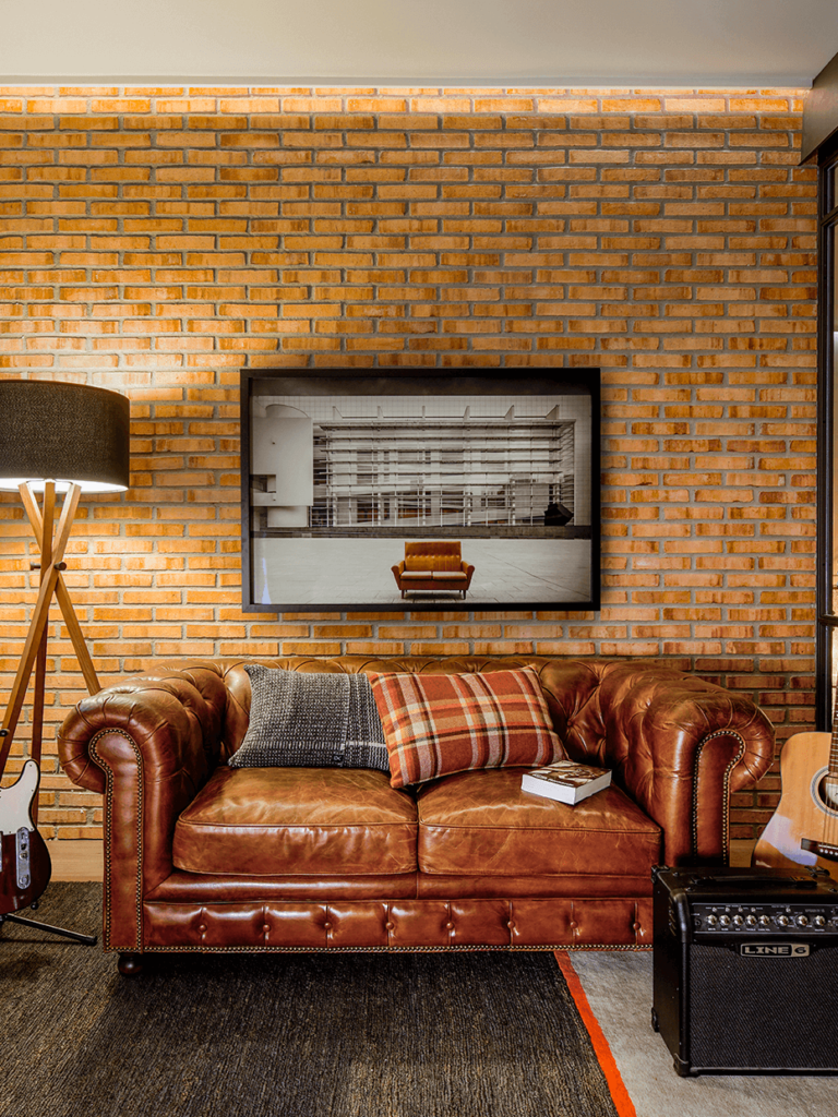 comment aménager garçonnière mur briques canapé rétro anglais chesterfield cuir cognac