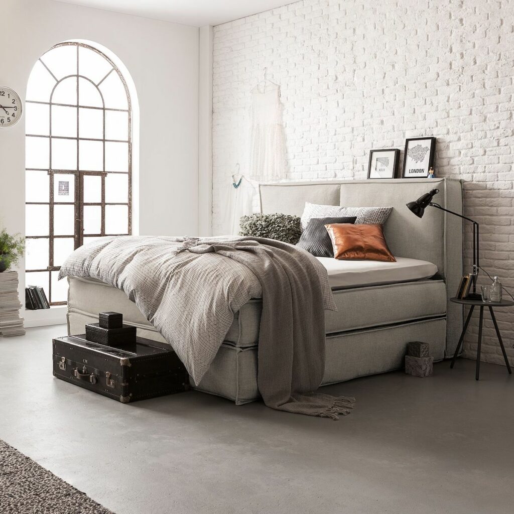 lit boxspring beige suite parentale mur en briques blanches fenêtre métallique noir