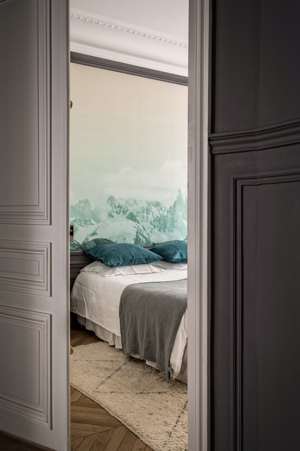 parisian style haussmann chambre soubassement moulure parquet tête de lit papier peint aquarelle montagne