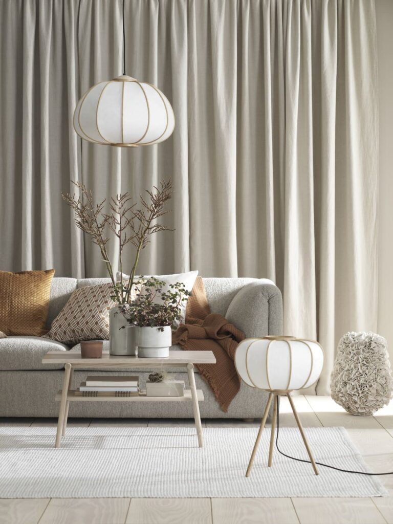 salon élégant canapé gris lampe laiton coussin orange table basse bois