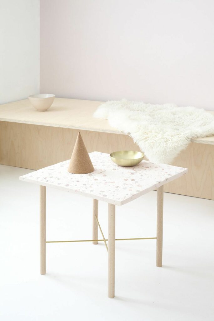 table carré pieds bois granito blanc rose pastel banquette bois tapis fourrure blanche