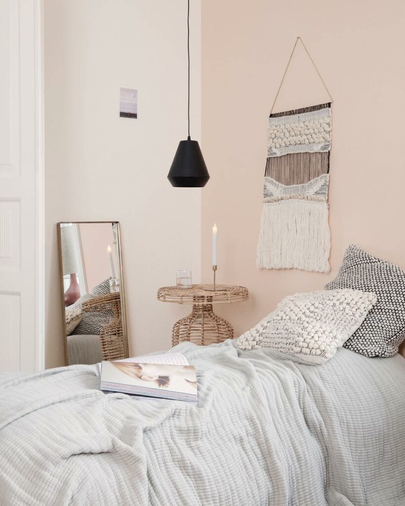 chambre mur crème vieux rose miroir rectangulaire coussin brodé table basse ronde osier