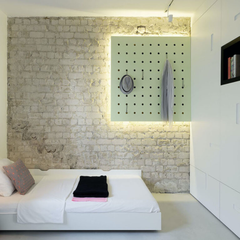 chambre sans fenêtre mur brique néons lumineux lit double