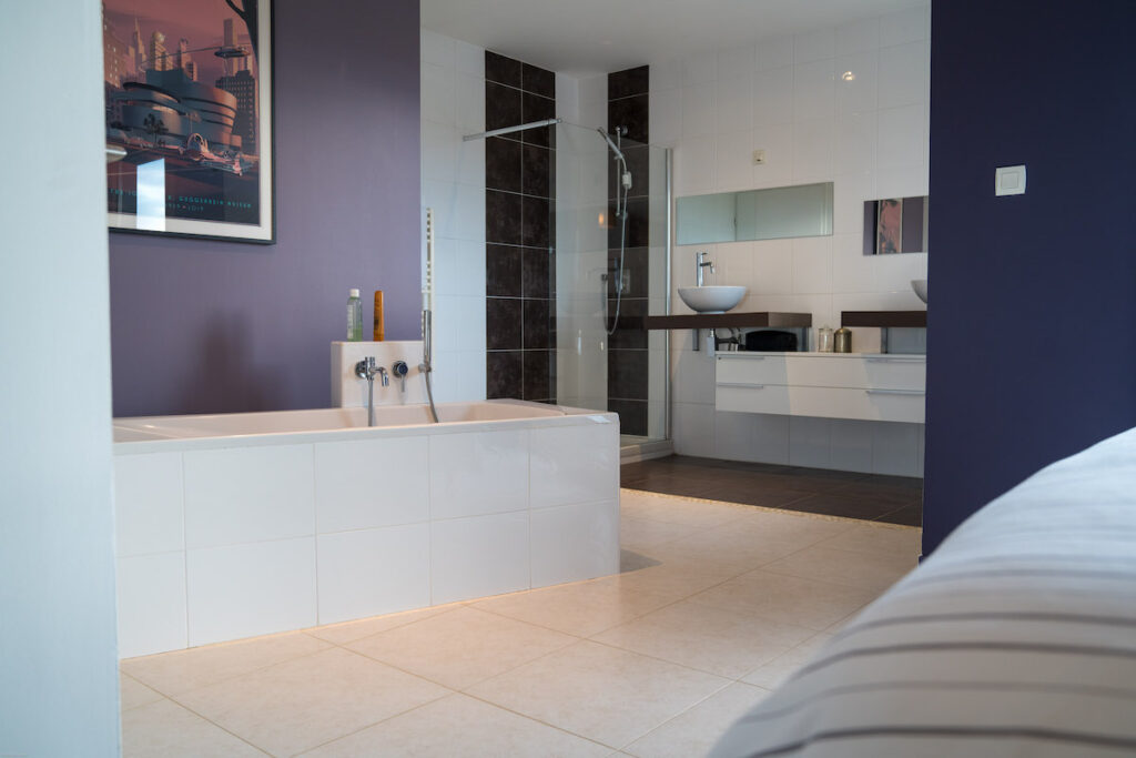 salle de bain ouverte baignoire îlot en carrelage blanc