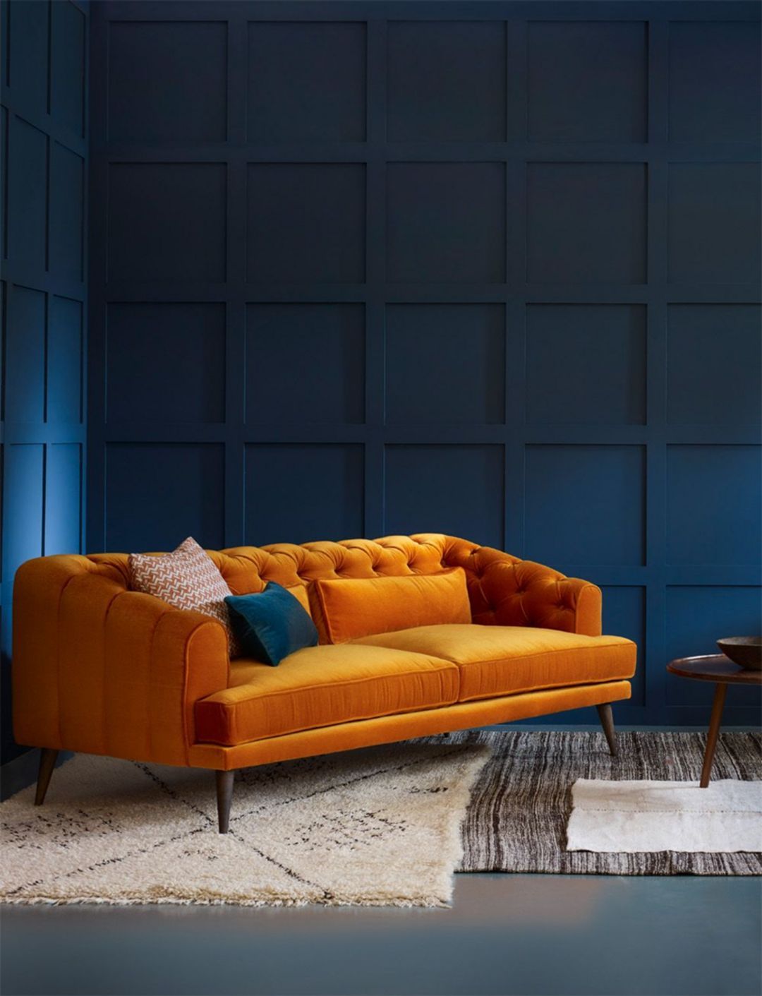 canapé orange mur bleu tapis fourrure blanc noir déco salon élégant