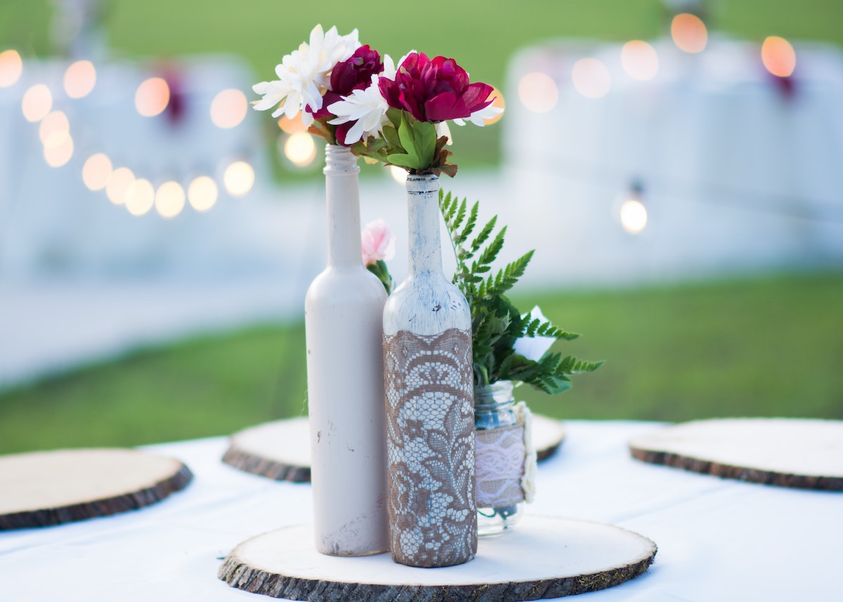 decoration de mariage extérieure table blanche bouteille personnalisée fleurs rouge